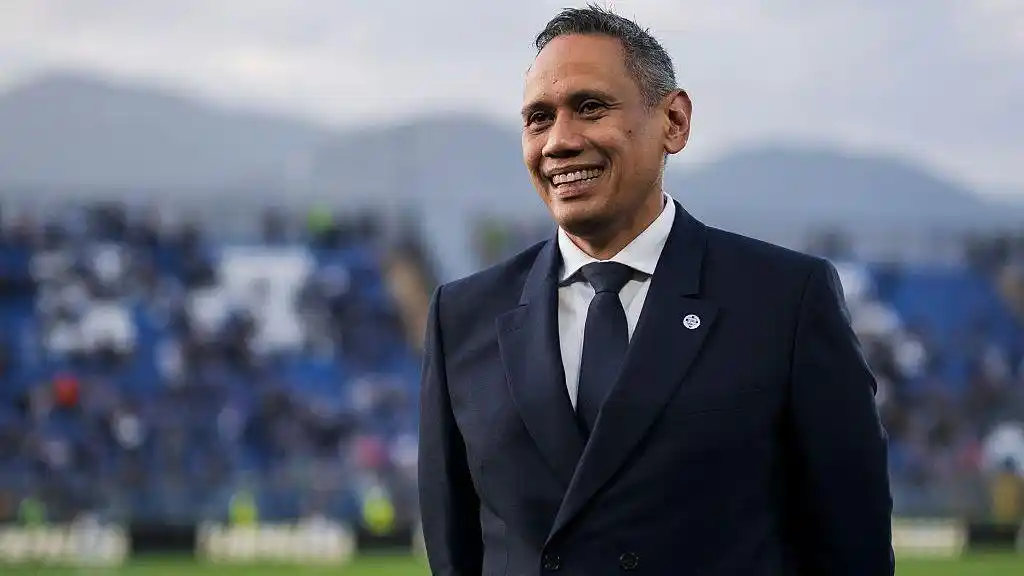 Como president Mirwan Suwarso, wearing a navy blue suit, white shirt and blue tie, smiles on the pitch before the Serie A match against Internazionale