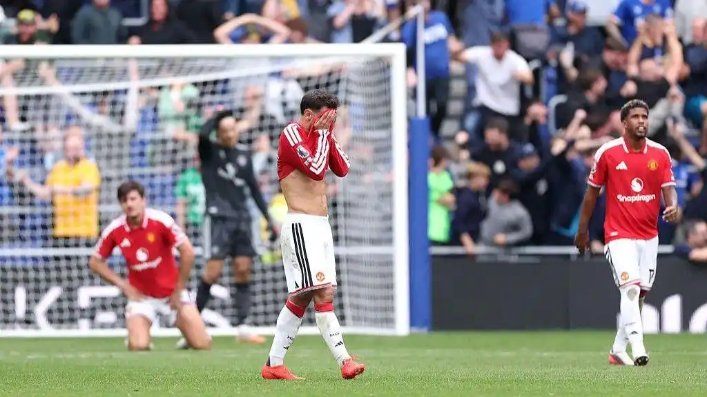 Manchester United players react after conceding a goal