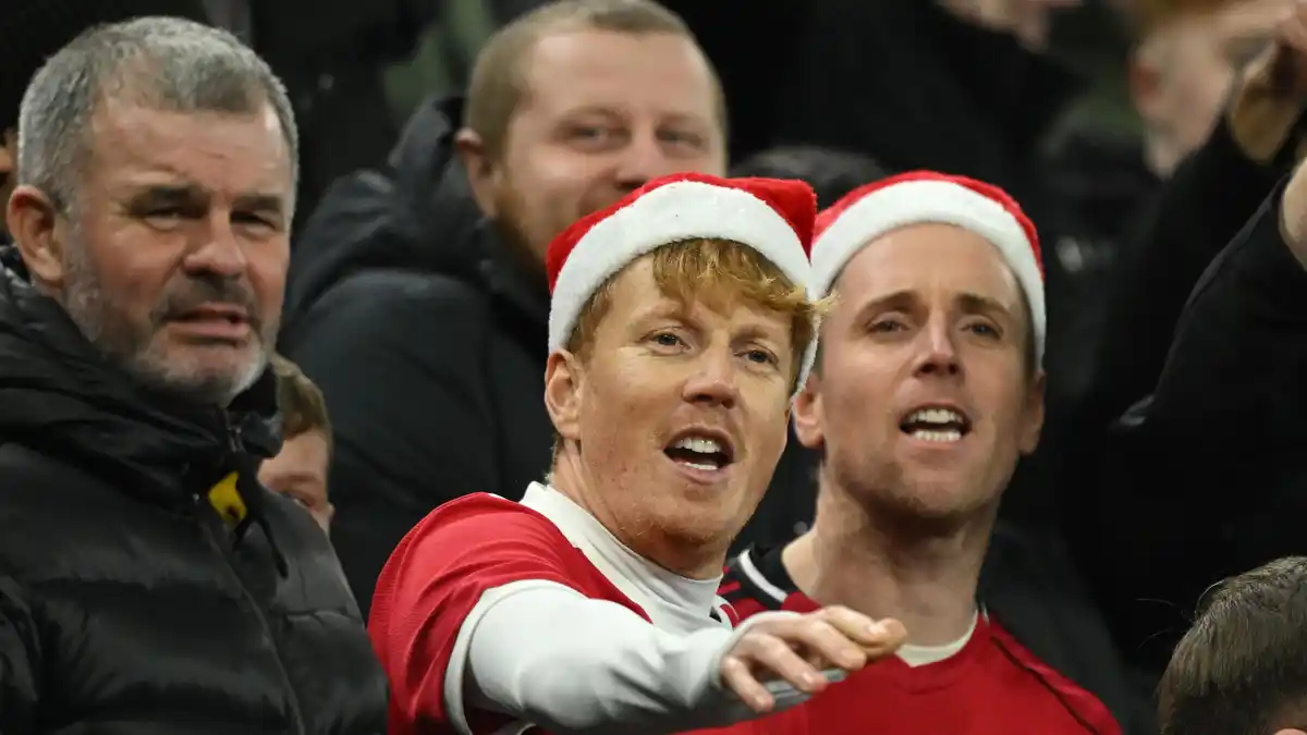 Manchester United fans wearing Santa hats at a match on 21 December 2026