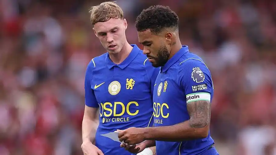 Reece James and Cole Palmer reading a note in the second half against Arsenal